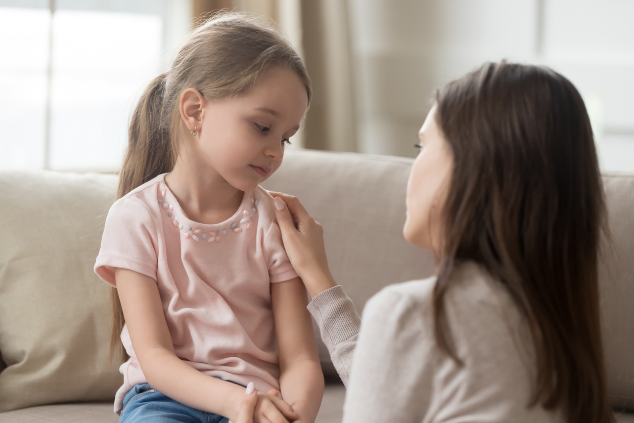 Mother comforting daughter in a home setting.
