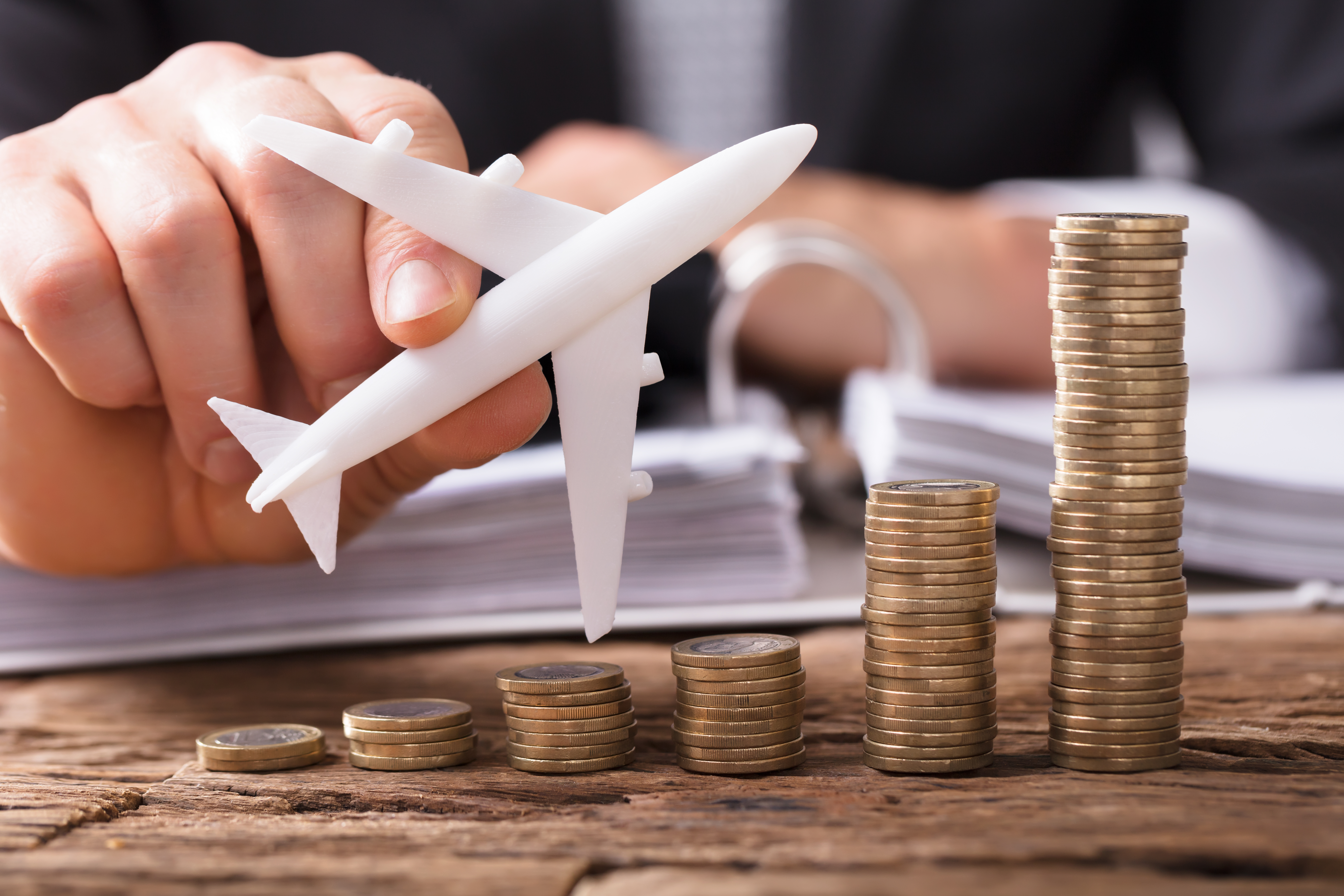man with coins and airplane figurine