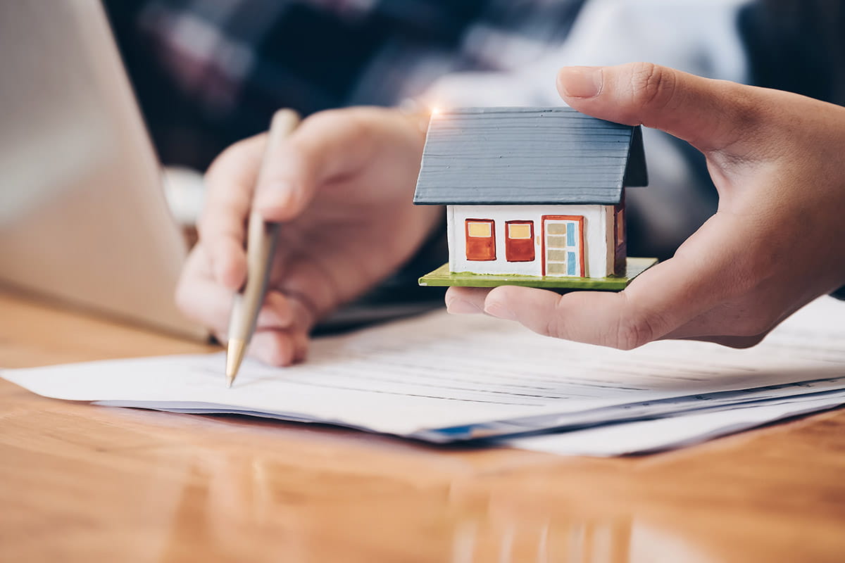 real estate attorney with house figurine in hand