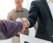 Close up of two men shaking hands in an office