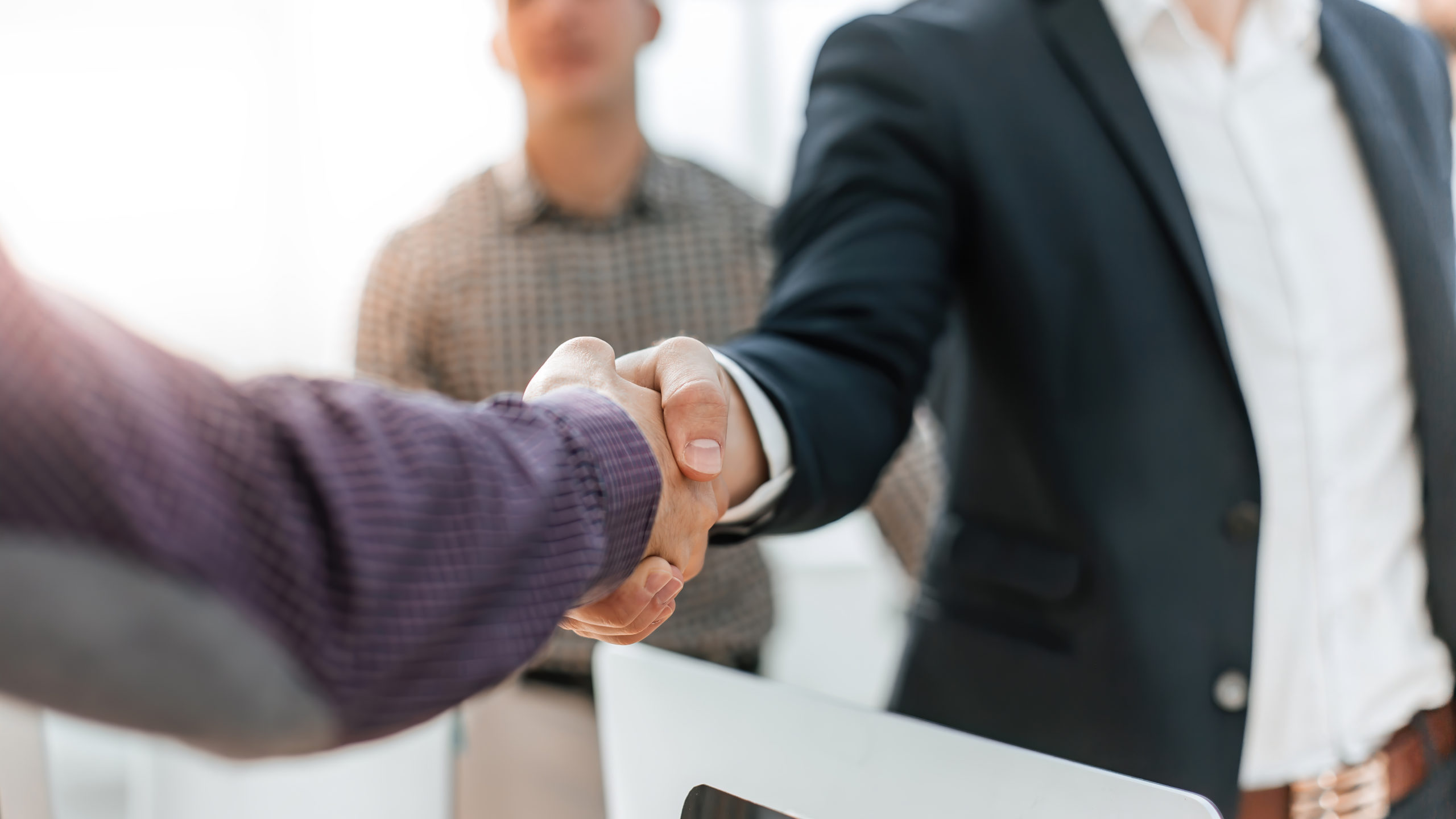 Close up of two men shaking hands in an office